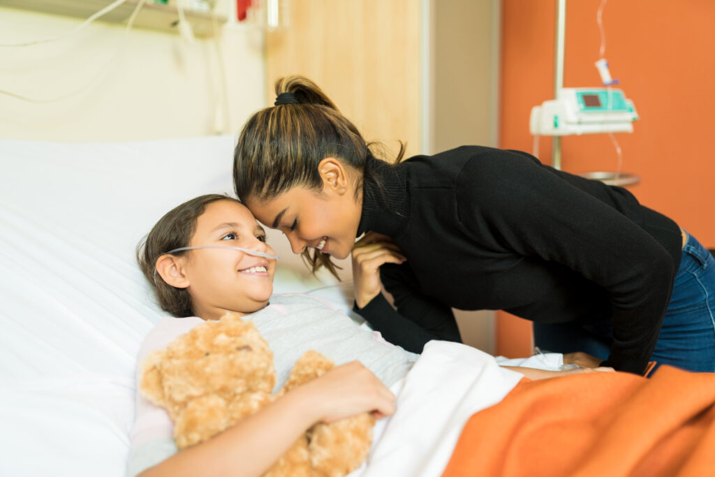 smiling mother unwell daughter by bed hospital visit GAPP Program