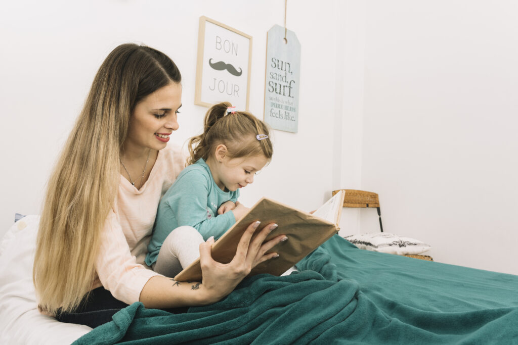 smiling woman reading book daughter bed GAPP Program